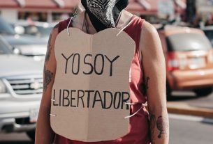 woman in red tank top wearing black and white mask