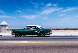green coupe on gray asphalt road